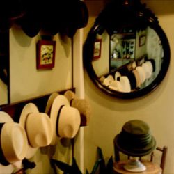Interior de tienda con espejo y sombreros panamá colgados