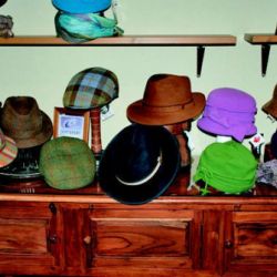 Expositor de madera con sombreros en interior de tienda