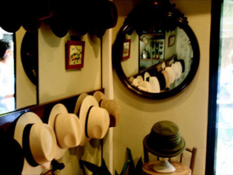 Interior de tienda con espejo y sombreros panamá colgados