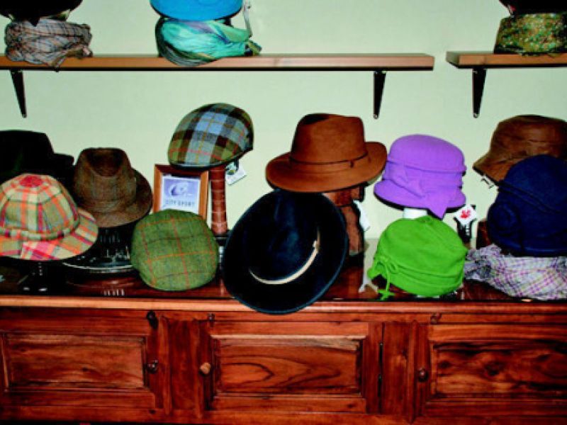 Expositor de madera con sombreros en interior de tienda